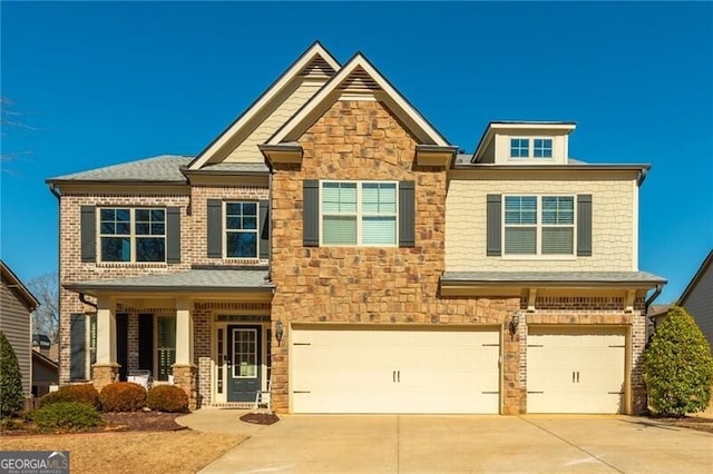 craftsman inspired home with an attached garage, stone siding, and concrete driveway