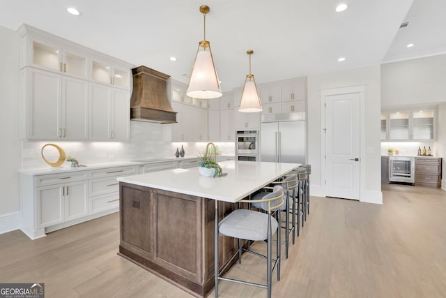 123 Candler Loop, Acworth, GA 30101 - kitchen featuring premium range hood, wine cooler, light wood finished floors, white cabinetry, and recessed lighting