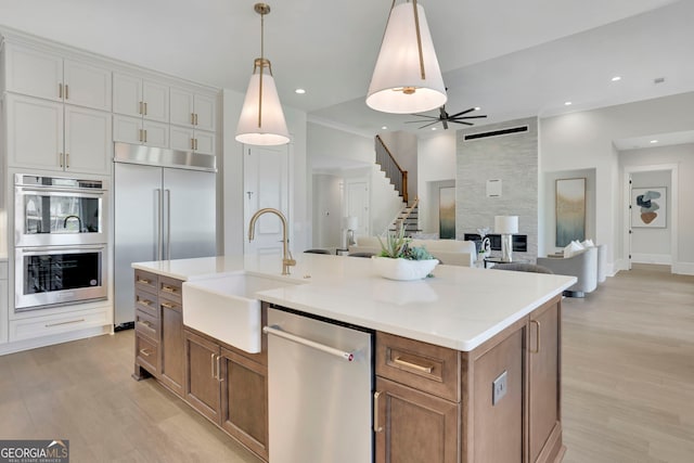 123 Candler Loop, Acworth, GA 30101 - kitchen featuring appliances with stainless steel finishes, brown cabinetry, light wood-type flooring, light countertops, and recessed lighting