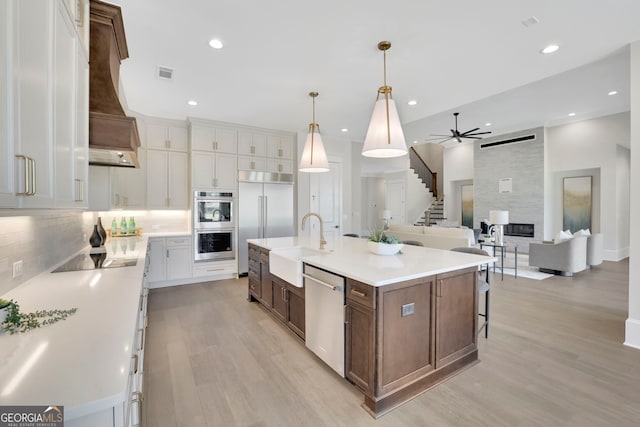 123 Candler Loop, Acworth, GA 30101 - kitchen featuring appliances with stainless steel finishes, premium range hood, light wood-style floors, backsplash, and light countertops