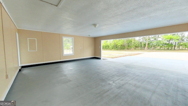 spare room featuring baseboards and a textured ceiling