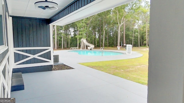 swimming pool featuring a water slide, central AC, and a patio area