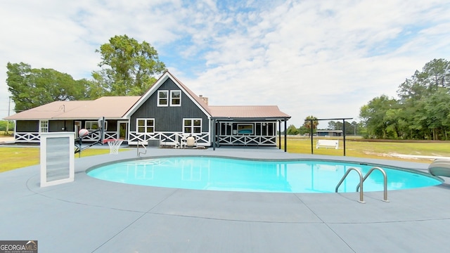 outdoor pool with a yard and a patio area