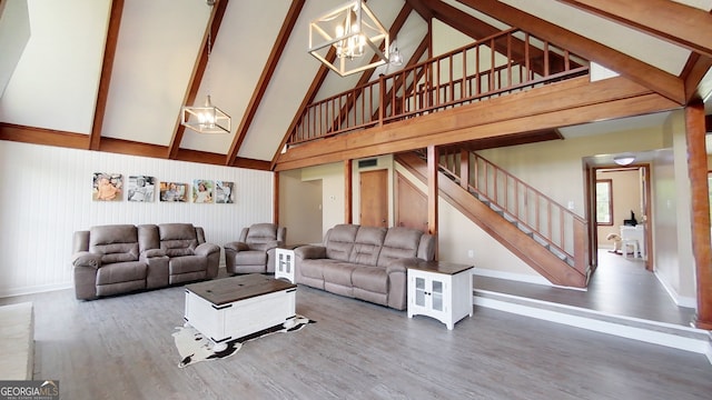 living area featuring high vaulted ceiling, a chandelier, wood finished floors, stairs, and baseboards