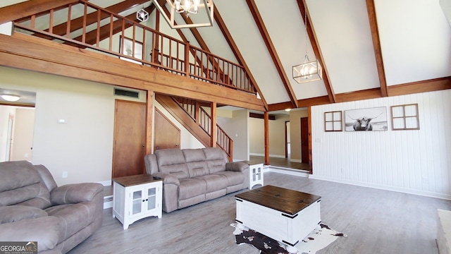 living room featuring high vaulted ceiling, a chandelier, wood finished floors, stairway, and baseboards