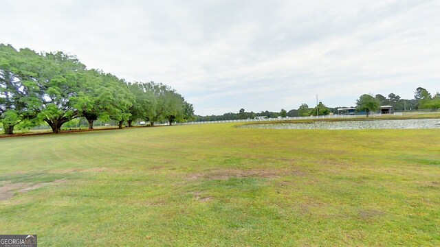 view of green lawn with a water view