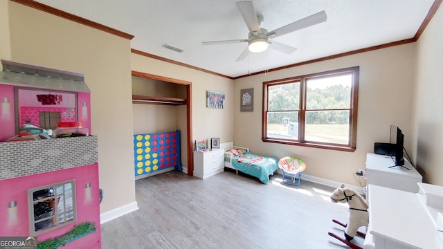 playroom with wood finished floors, baseboards, crown molding, and a ceiling fan