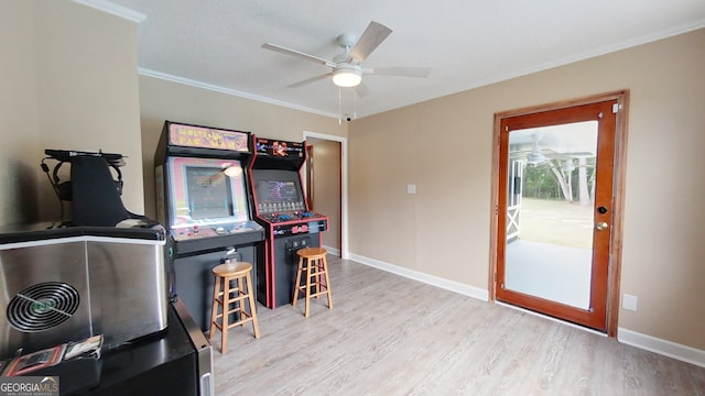 rec room featuring wood finished floors, ceiling fan, crown molding, and baseboards