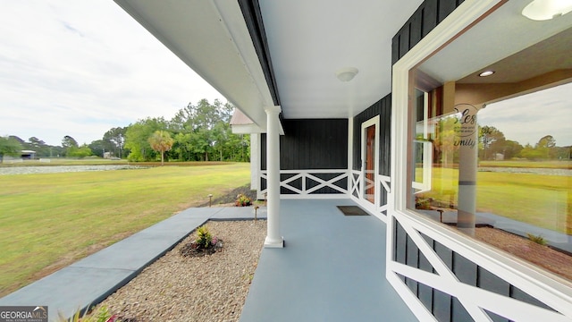view of patio featuring a water view and covered porch