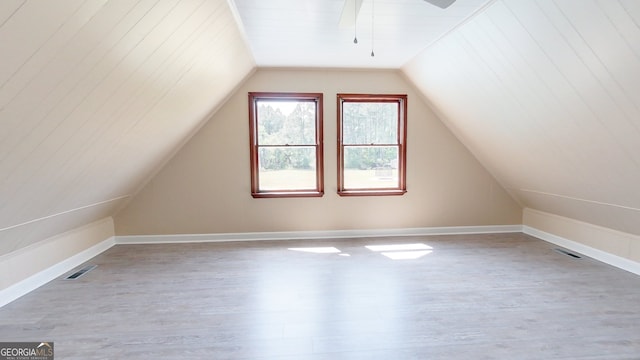 bonus room featuring wood finished floors, vaulted ceiling, a ceiling fan, and baseboards