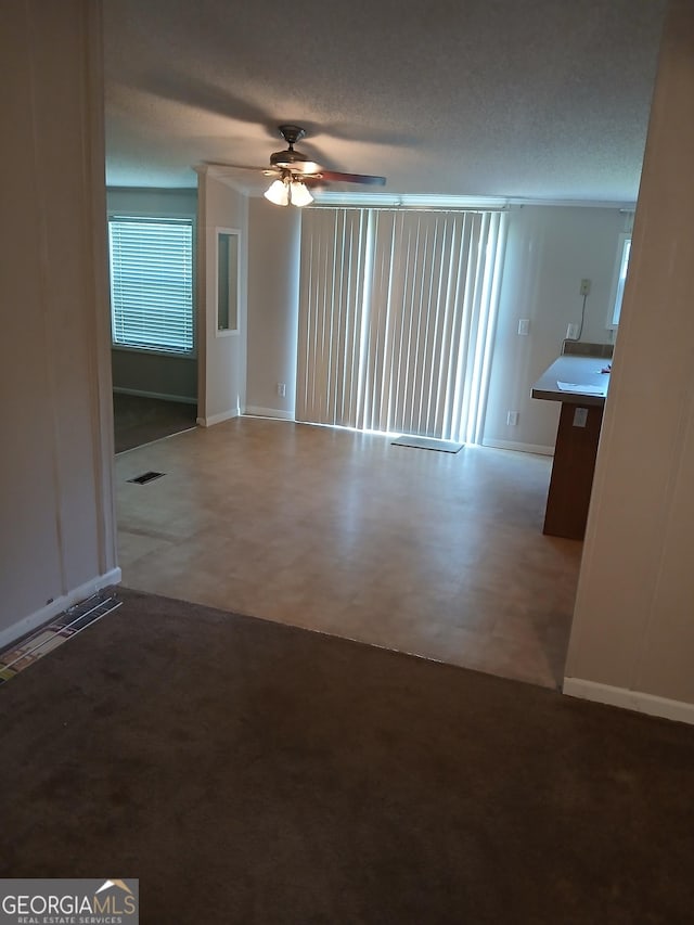 2791 Pulaski Rd, Statesboro, GA 30458 - empty room featuring a ceiling fan, a textured ceiling, baseboards, and tile patterned floors