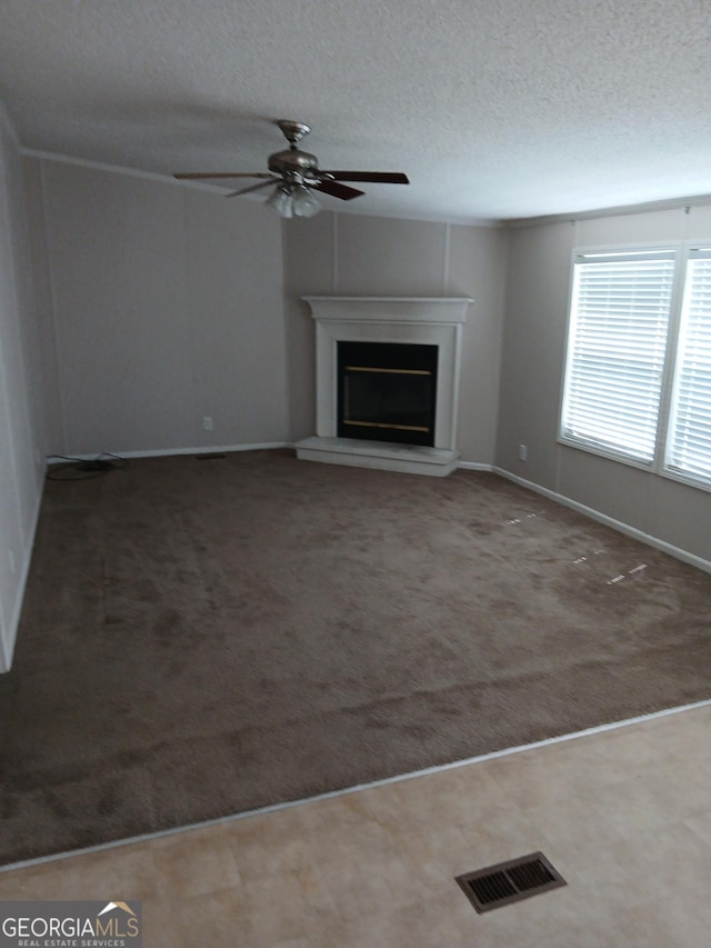 2791 Pulaski Rd, Statesboro, GA 30458 - unfurnished living room with visible vents, baseboards, a fireplace with raised hearth, a textured ceiling, and a ceiling fan