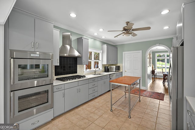 804 Eagleview, Anderson, SC 29625 - kitchen with wall chimney exhaust hood, gray cabinetry, stainless steel appliances, arched walkways, and tasteful backsplash