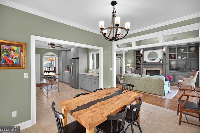 804 Eagleview, Anderson, SC 29625 - dining area featuring a chandelier, ornamental molding, light tile patterned flooring, a stone fireplace, and a ceiling fan