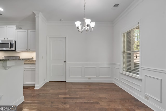 328 Spence Cir, Ball Ground, GA 30107 - unfurnished dining area with a chandelier, crown molding, dark wood-style flooring, and a wainscoted wall
