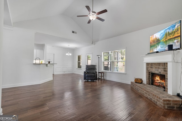 328 Spence Cir, Ball Ground, GA 30107 - living room with a brick fireplace, dark wood-type flooring, ceiling fan, a chandelier, and high vaulted ceiling