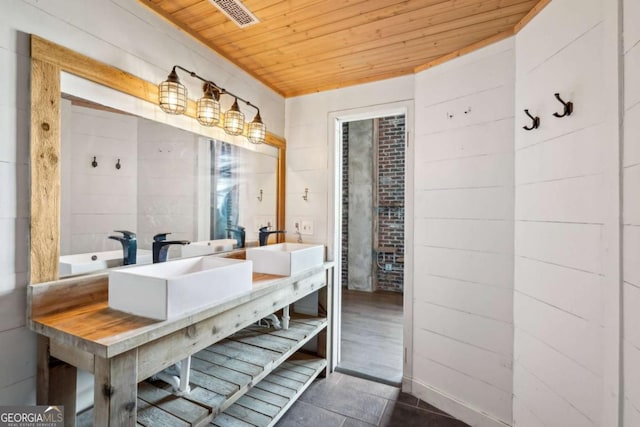 bathroom featuring tile patterned floors, wood ceiling, a sink, and a stall shower