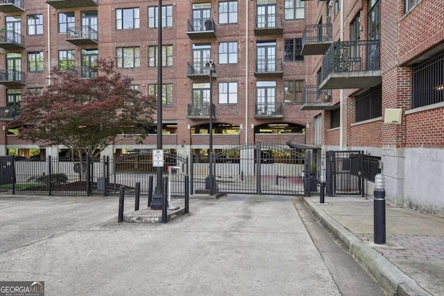 view of road with a gated entry, curbs, and a gate