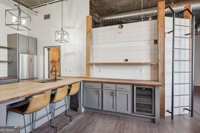kitchen featuring wood counters, a sink, gray cabinetry, and open shelves