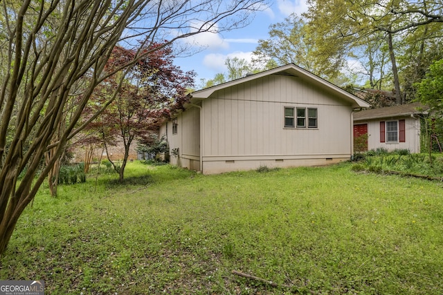 view of side of property featuring a yard and crawl space