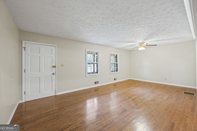 unfurnished room featuring wood finished floors, ceiling fan, baseboards, and visible vents