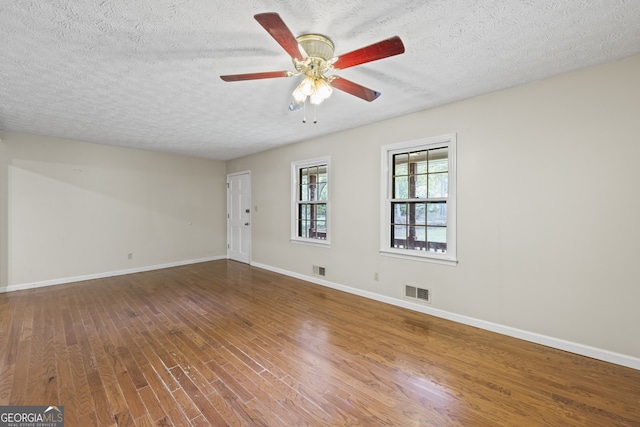 unfurnished room featuring visible vents, baseboards, and wood finished floors