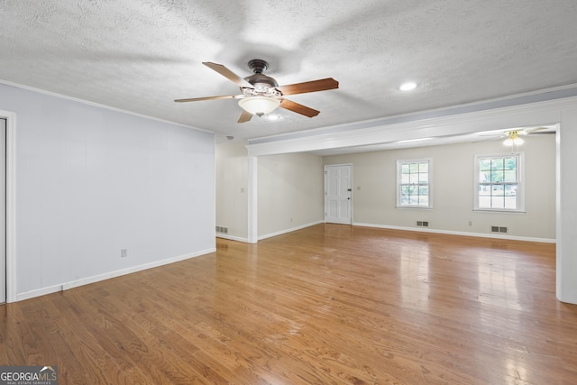 spare room featuring crown molding, visible vents, ceiling fan, and light wood-type flooring