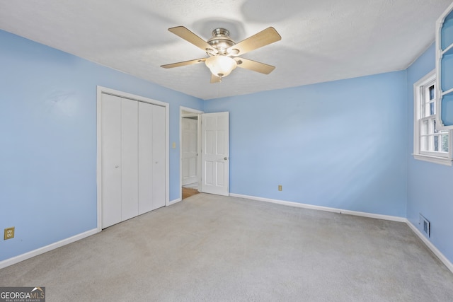 unfurnished bedroom with a closet, baseboards, carpet, and visible vents