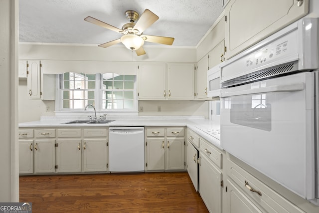 kitchen featuring dark wood finished floors, white appliances, a textured ceiling, a ceiling fan, and a sink