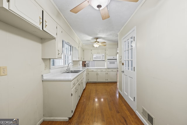 kitchen featuring ceiling fan, white appliances, visible vents, light countertops, and a sink