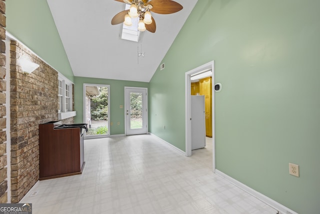 interior space featuring baseboards, visible vents, light floors, high vaulted ceiling, and ceiling fan