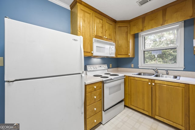 kitchen featuring white appliances, light countertops, visible vents, light floors, and a sink
