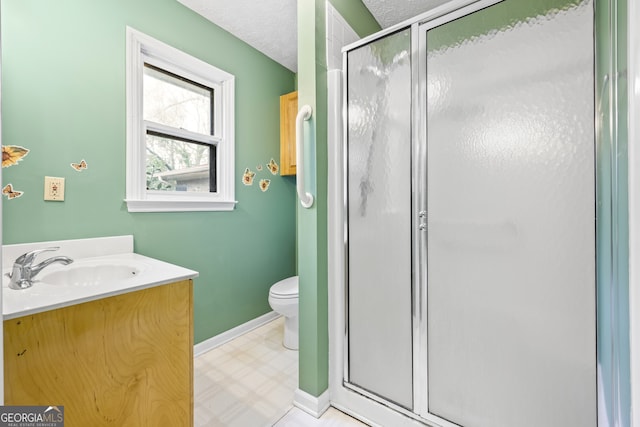 full bath featuring a shower stall, a textured ceiling, vanity, toilet, and tile patterned floors