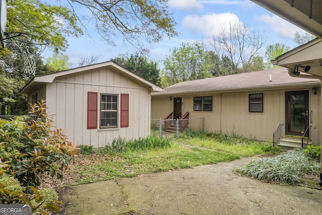 exterior space with entry steps, board and batten siding, and fence