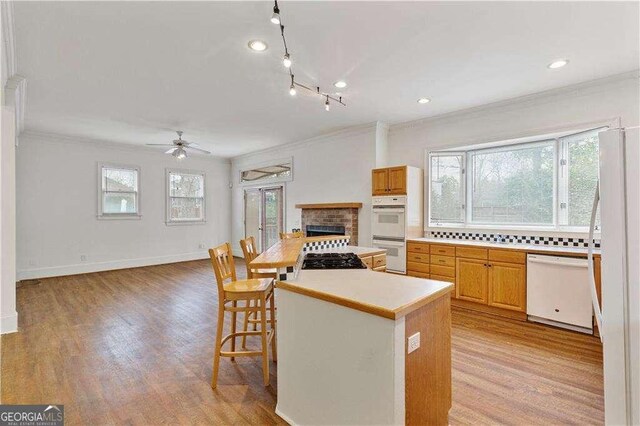 873 Monroe Cir NE, Atlanta, GA 30308 - kitchen featuring light countertops, ceiling fan, white appliances, light wood-style floors, and crown molding