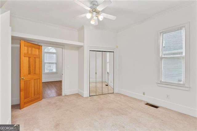 873 Monroe Cir NE, Atlanta, GA 30308 - unfurnished bedroom with baseboards, a closet, crown molding, visible vents, and carpet