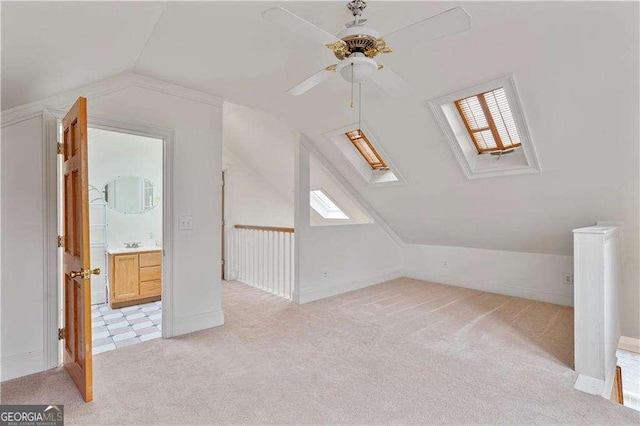 873 Monroe Cir NE, Atlanta, GA 30308 - additional living space with light colored carpet, ceiling fan, baseboards, and lofted ceiling with skylight