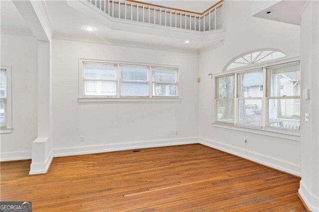 873 Monroe Cir NE, Atlanta, GA 30308 - empty room with a high ceiling, crown molding, wood finished floors, and baseboards