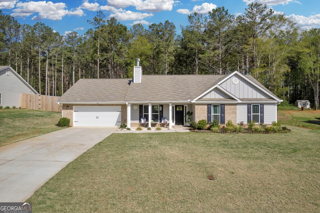 119 Camp Ct, Bethlehem, GA 30620 - ranch-style house with a garage, board and batten siding, fence, brick siding, and driveway