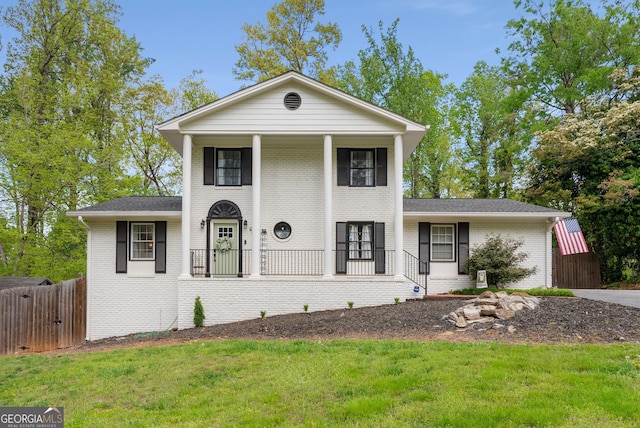 503 Duke Dr, Marietta, GA 30066 - neoclassical home with brick siding, a front yard, a porch, and fence