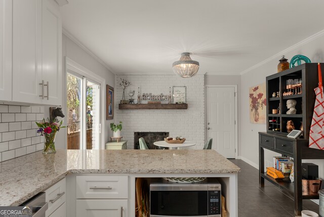 503 Duke Dr, Marietta, GA 30066 - kitchen with stainless steel microwave, light stone counters, crown molding, backsplash, and white cabinets