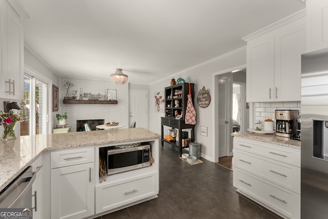 503 Duke Dr, Marietta, GA 30066 - kitchen with white cabinets, ornamental molding, appliances with stainless steel finishes, a peninsula, and backsplash