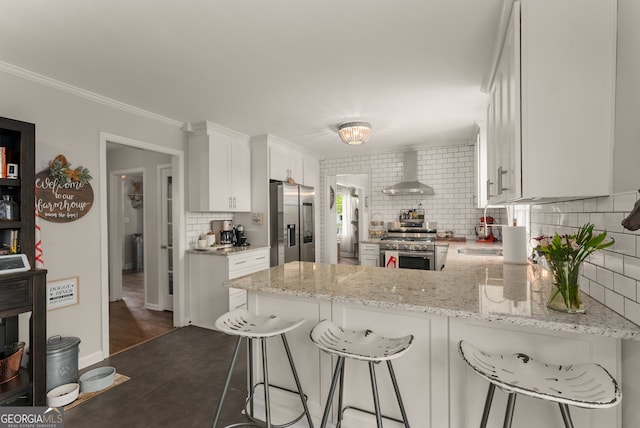 503 Duke Dr, Marietta, GA 30066 - kitchen with light stone countertops, wall chimney range hood, white cabinets, stainless steel appliances, and decorative backsplash