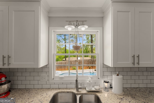 503 Duke Dr, Marietta, GA 30066 - kitchen with light stone countertops, tasteful backsplash, a sink, and white cabinets