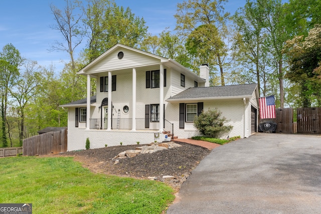503 Duke Dr, Marietta, GA 30066 - neoclassical / greek revival house featuring aphalt driveway, a porch, fence, brick siding, and a chimney