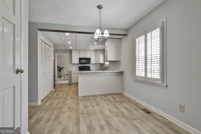 31 Festiva Dr, Newnan, GA 30263 - kitchen with light countertops, backsplash, black appliances, visible vents, and a sink