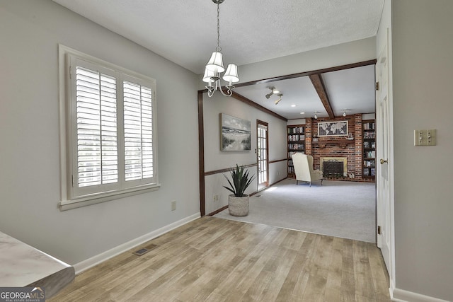 31 Festiva Dr, Newnan, GA 30263 - dining room with a chandelier, a fireplace, a textured ceiling, visible vents, and beamed ceiling