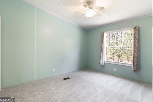 unfurnished room featuring a textured ceiling, visible vents, carpet flooring, and ceiling fan
