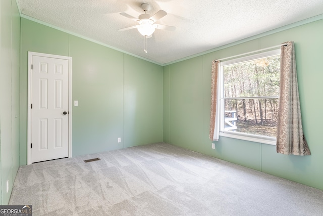 unfurnished room with crown molding, carpet, a textured ceiling, and a ceiling fan