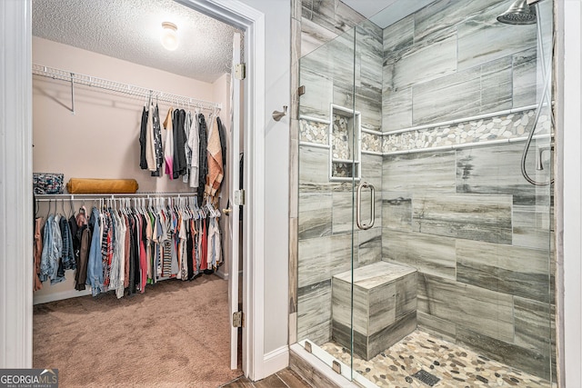 60 Bartlett Way, Dallas, GA 30157 - full bathroom featuring a stall shower, a spacious closet, a textured ceiling, and baseboards